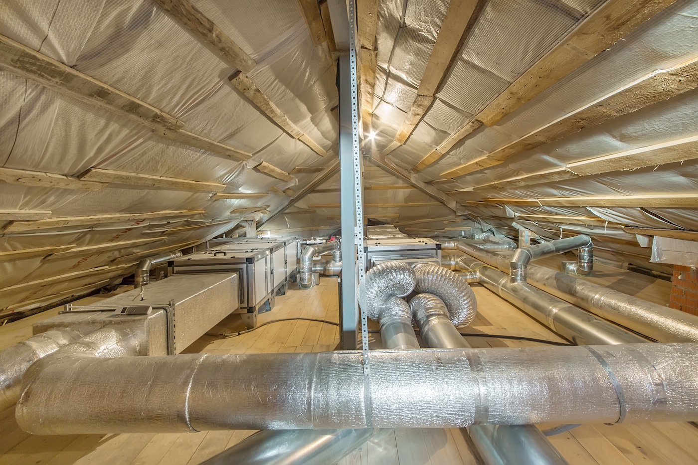 Commercial HVAC system in an insulated attic with large ventilation ducts.