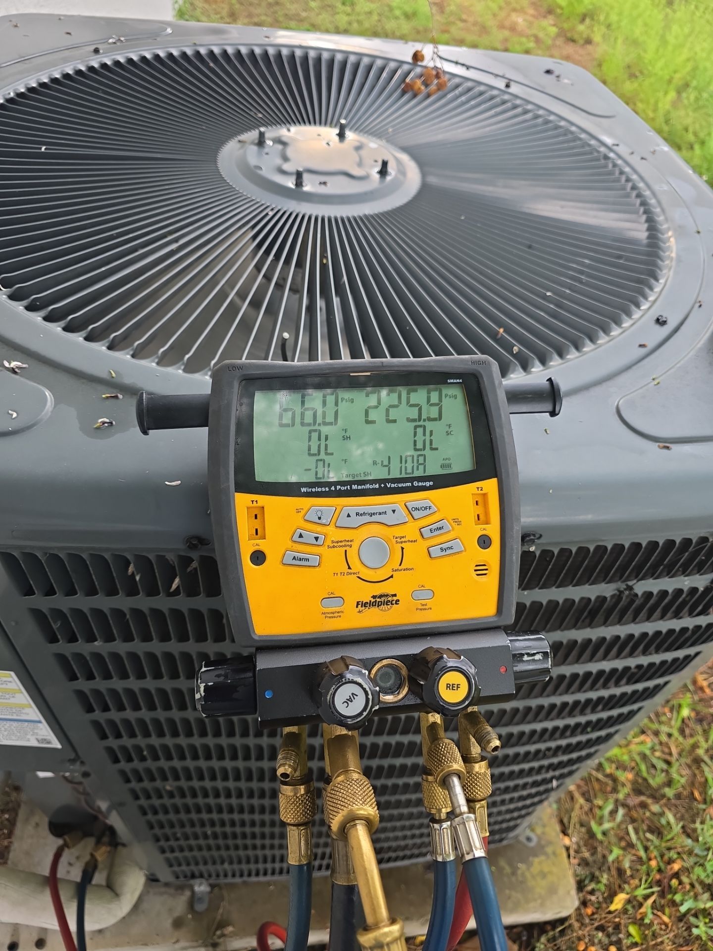Air conditioning unit with digital manifold gauge for pressure measurement.