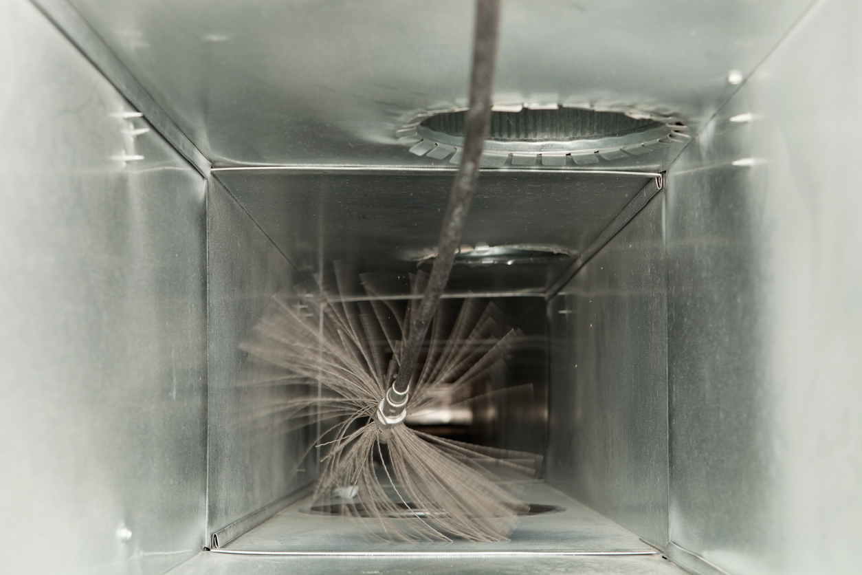 Brush cleaning the inside of an air duct, improving indoor air quality and HVAC efficiency.