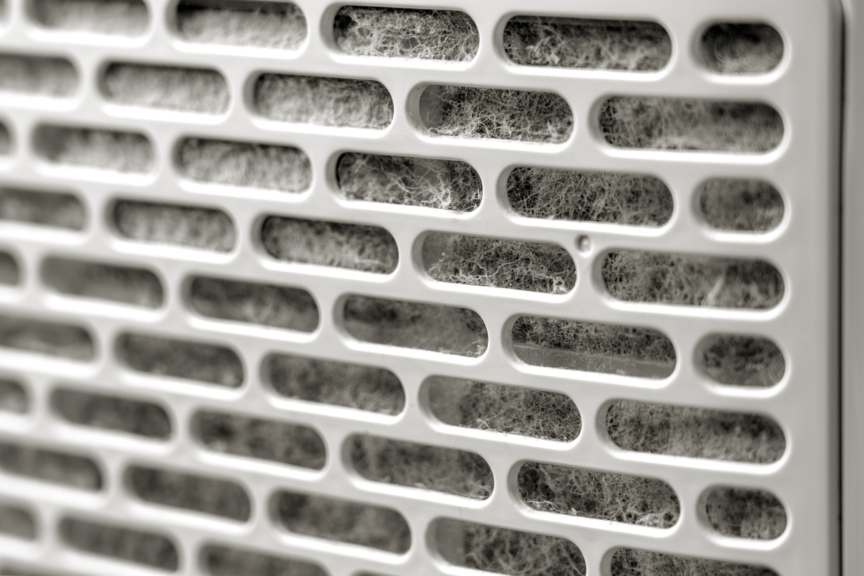 Close-up of a dusty air filter showing the buildup of dirt and particles trapped in the mesh.